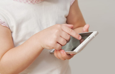 Baby girl hand pointing white smart phone isolated on white background