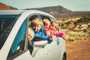 family travel by car- happy mother with tree kids in mountains
