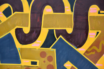 Some elements of a large and composite graffiti pattern on the wall, made with different colors of aerosol paints