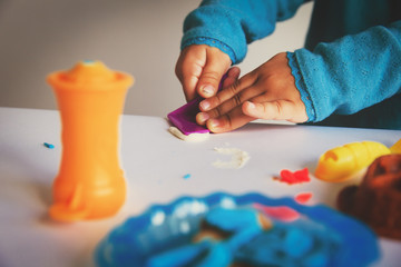 Child playing with clay molding shapes