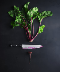 cut beetroot and knife on a black background