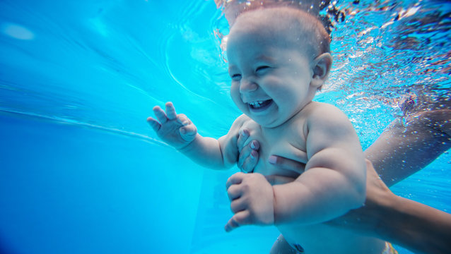Baby background. Happy infant learn to swim, dive underwater with fun in pool to keep fit.