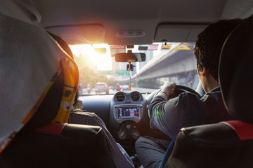 A man driving in car on the road. view from rear