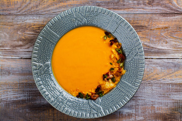 Vegetable pumpkin and carrot soup served with pumpkin seeds, potato chips and roasted bacon. Space for text