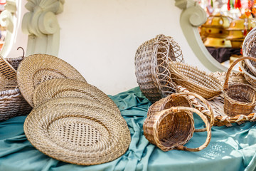 Different dishes and baskets made of wicker, on a table in a market