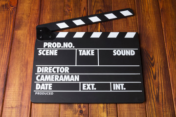 Obraz premium Black with white letters clapper against dark wood.