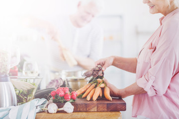 Woman in pink shirt is peeling carrots