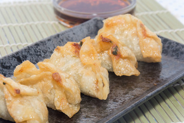 fried pork gyoza dumplings on black plate