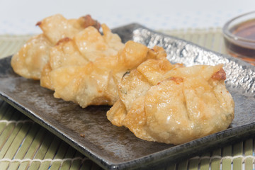 fried pork gyoza dumplings on black plate