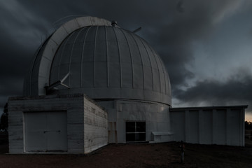 Disused observatory at night with storm clouds