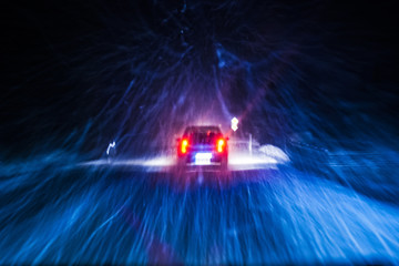 Car driving during winter snowstorm. Motion blur.