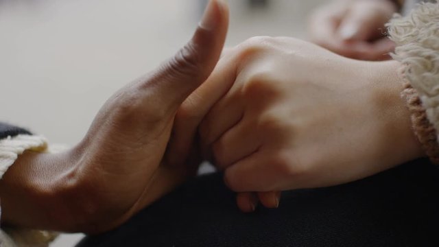 Two female hands come together and hold each other