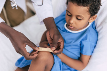 african american doctor putting adhesive plaster