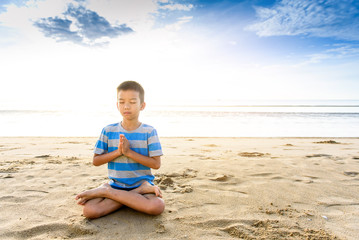 Boy do Yoga on the beach