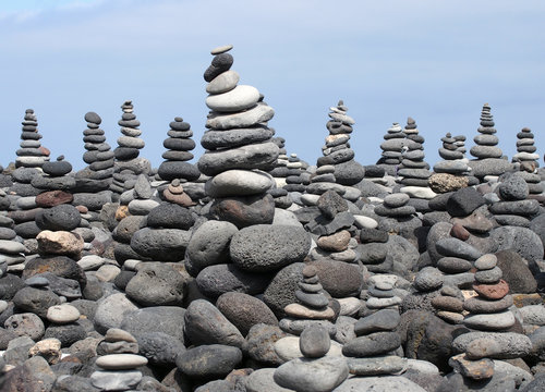 rock art piles and towers of grey stones and pebbles on a beach