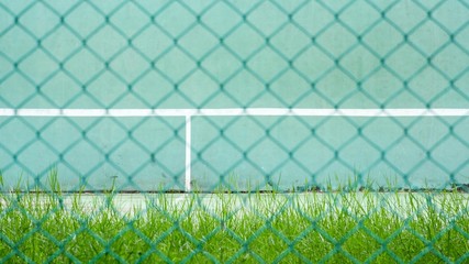 green tennis court and wall for practice - backside green metal cage