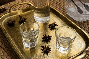 Glasses of traditional drink Ouzo or Raki on bronze dish with anise star seeds
