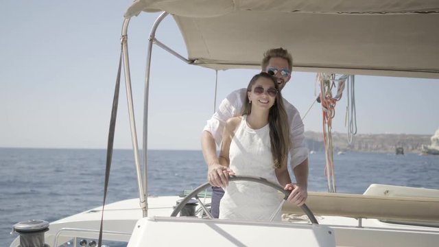 4k travel video beautiful honeymoon couple steering yacht together on sunny summer day

