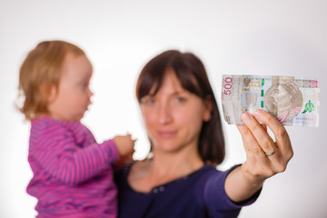 Mother with little daughter holds in hand 500 zloty banknote. Symbol of 500 + polish program for families.