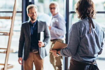 waiter greeting businessmen in cafe