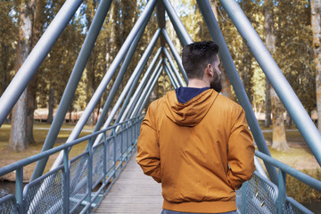 Man walking along the bridge that crosses the river.