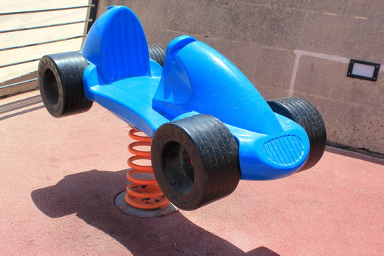 Federwippe als Rennauto auf einem Spielplatz