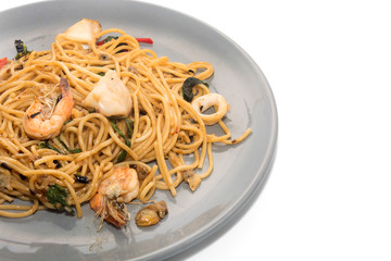 spaghetti with seafood on plate isolated on white background