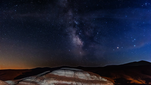 Milky way on starry sky over red mountains
