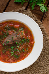 Vegetable borscht. Traditional Ukrainian and Russian soup. Wooden background. Close-up. Top view