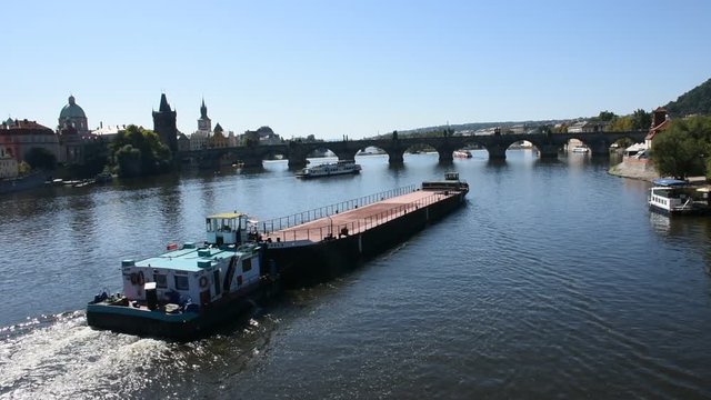 Barge and Tugboat cargo ship sailing Vltava river near Charles Bridge on August 30, 2017 in Prague, Czech Republic