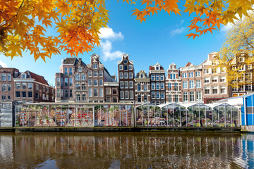 Autumn season at Amsterdam street traditional ancient dutch colorful buildings and flower market on Single canal in Amsterdam, Netherlands.