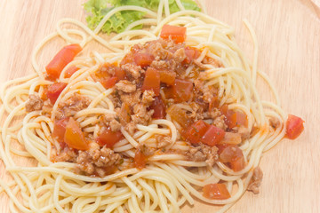 spaghetti with sauce on wooden plate