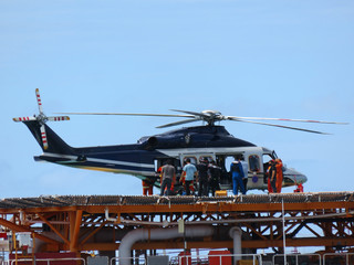 Helicopter or chopper land at oil and gas platform area for get and sent passenger from onshore hangar to offshore platform. Crew change working rotation by helicopter.    © chanjaok1