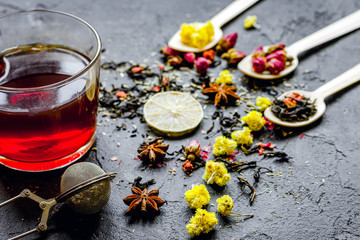 Teacup and herbs on grey background
