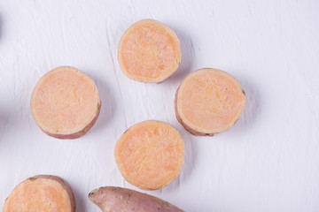 Top view of raw sweet potato on the white table. Slices.