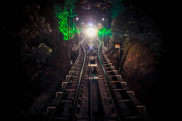 Naklejka premium Modern driver-less metro train rush forward, along night Malaysia, bright road lights at night.