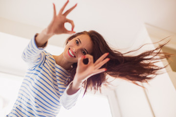 Portrait of young cheerful beautiful woman who showing sign 