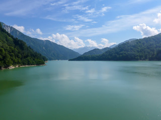 The lake with mountain and blue sky with cloud above the Kurobe dam in Japan