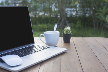 Wooden table with computer and coffee cup. View from above with copy space.