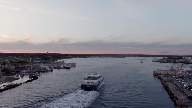 Aerial of Rhode Island pier with a ferry heading into dock at sunset.
