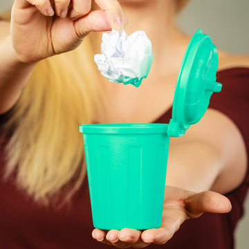 Woman Putting Paper Into Small Trash Can