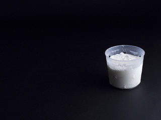 French fromage blanc (fresh cheese) in small portion sized cheese basket isolated on black background