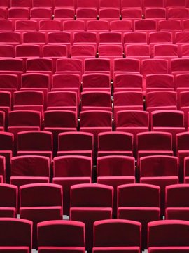 Rangées de fauteuils rouges dans une salle de spectacle
