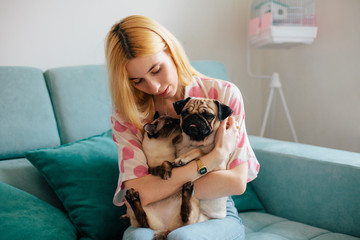 Beautiful blond woman holding her pets in her lap