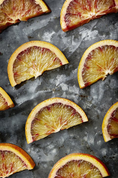 Slices of blood oranges on a metal surface