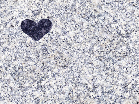Black heart on a granite stone background