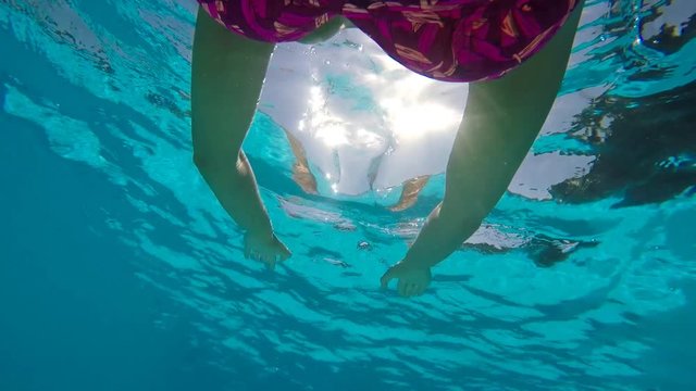 Woman swimming in pool at sunny day.