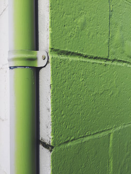 Detail of painted green corner of building and gutter pipe