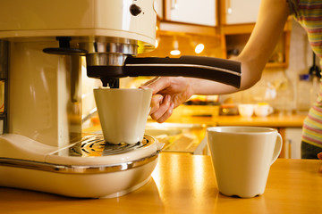 Woman making hot drink in coffee machine