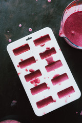 Top view of a popsicle mold and ingredients to make ice cream at home, summer concept